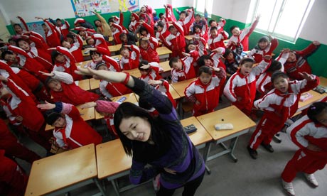 A teacher leads her students doing body exercise 