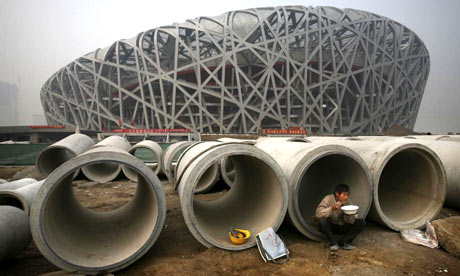 A Chinese worker eats lunch next to the national stadium which is currently under construction for the 2008 Beijing Olympic games