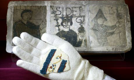 A curator holds a replica of a fragment of the Bayeux Tapestry, stolen by artist Charles Stodhard when he was commissioned to draw a replica in 1816