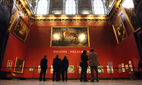 Visitors look at paintings (at bottom) by Picasso in the Louvre in Paris 
