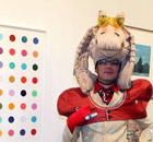 A visitor poses near a Damien Hirst piece at the Nitsch/Paragon gallery at Art Basel Miami Beach