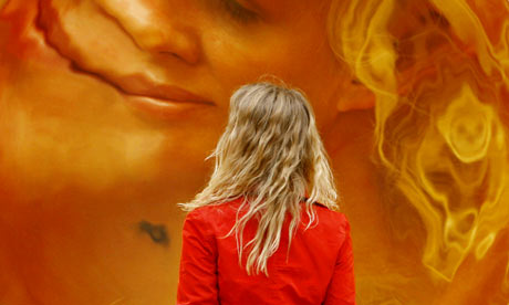 A woman is reflected in one of Anish Kapoor's stainless-steel sculptures