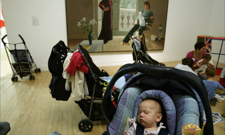 A baby in a pushchair in front of David Hockney's Mr and Mrs Clark and Percy at Tate Britain