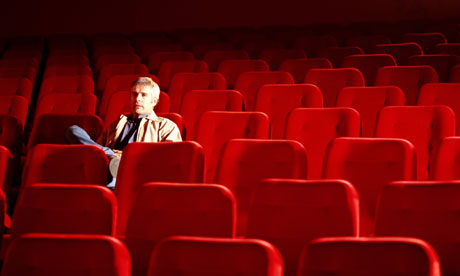 Man sitting alone in an empty cinema