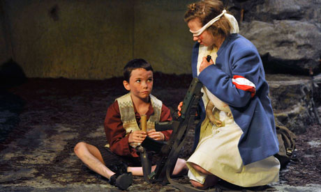 The Wheel A blindfolded girl holds a gun while a smaller boy watches