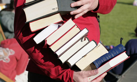 Man holding a pile of books