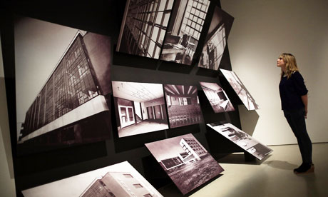 A visitor looks at photographs of the Bauhaus building at Dessau