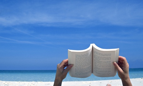 Person reading a book on the beach