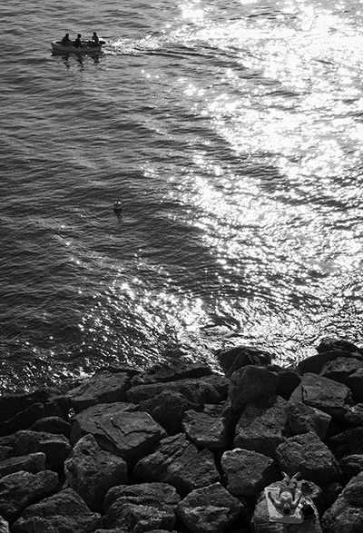 Photography competition: man sleeps on rocks by seafront