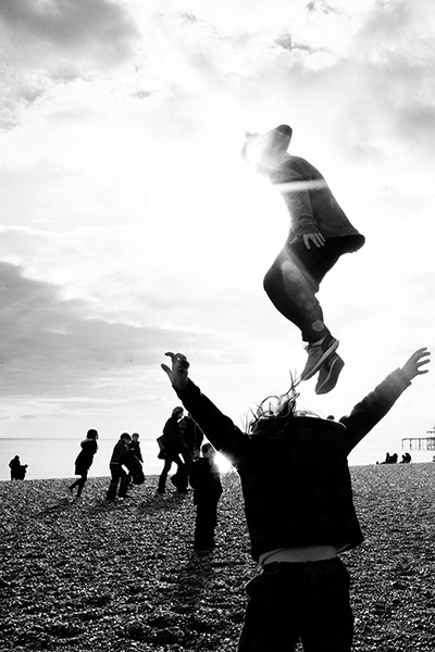 Photography competition: child jumps from a metal sculpture at beach
