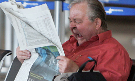 A newspaper reader yawns