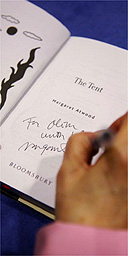 Margaret Atwood signing a book with 'The Long Pen'