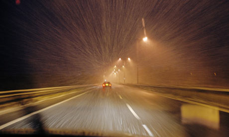 Snow falls on a motorway