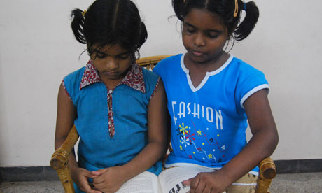 Indian sisters reading a book