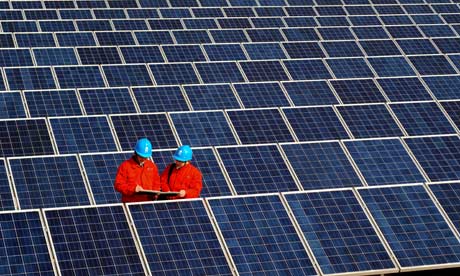 Workers check solar panels on a factory roof in Changxing, in eastern China