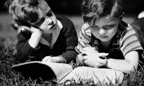 Two boys reading outdoors