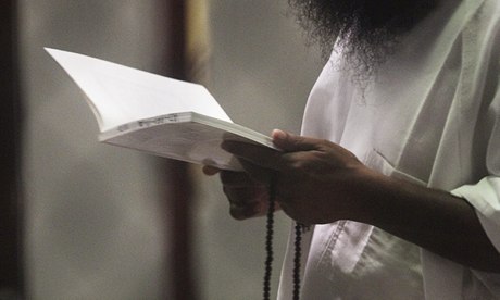 A prisoner reads a book in Camp Delta, Guantánamo Bay