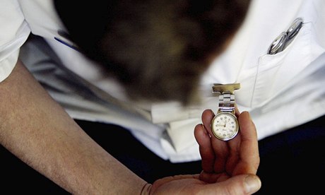 A nurse checks his fob watch