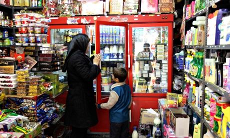 An Iranian woman and a boy shop at a gro