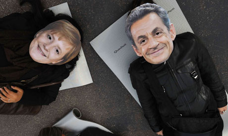 Demonstrators in Sarkozy and Merkel masks