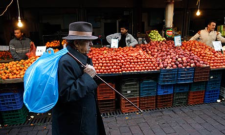 A man walks past fruit stalls at Athens main food market