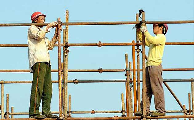 Construction workers in Hefei, China, on the day the country revealed economic growth had slowed to 9% 