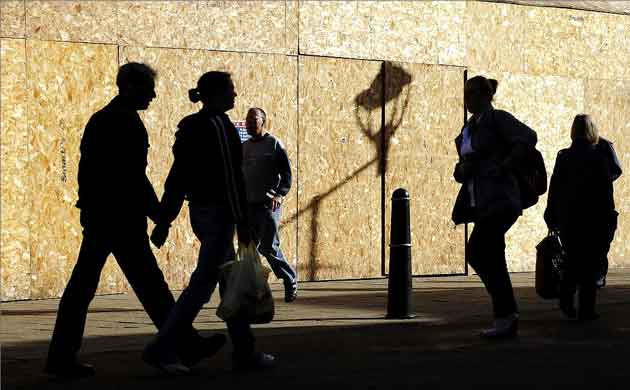 As the recession bites, shoppers pass a boarded-up building in Rotherham, South Yorkshire