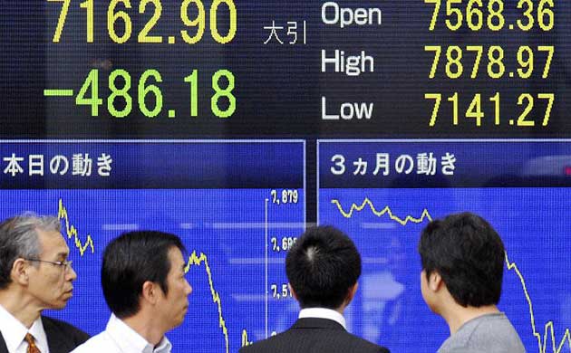 People look at stock prices in Tokyo, Japan