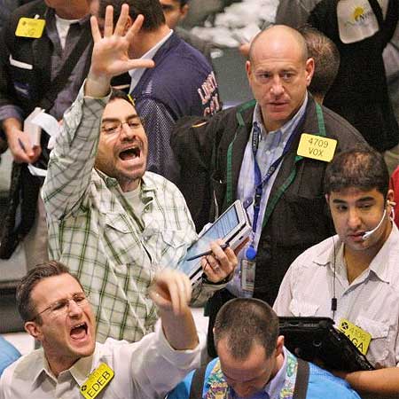 Oil traders gesture as they work in the oil futures pit at the New York Mercantile Exchange on the day prices dipped again