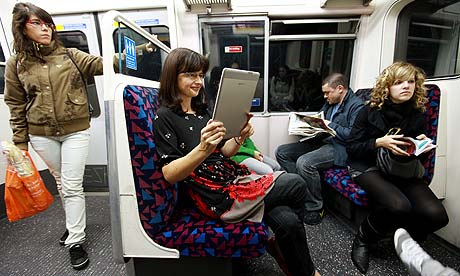 Woman reading a Kindle on the Tube