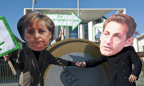 -Protesters dressed as German Chancellor Angela Merkel and French President Nicolas Sarkozy