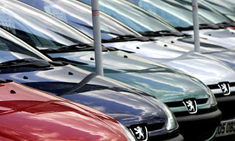 New Peugeot vehicles are lined up at a d