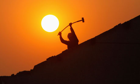 A labourer works at demolishing a residential site in Shanghai