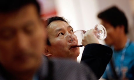 A man drinks Sarome Bordeaux vineyard from France at the 6th Shanghai International Wine Trade Fair