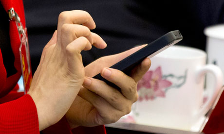A Chinese Communist party delegate uses her iPhone, November 2012