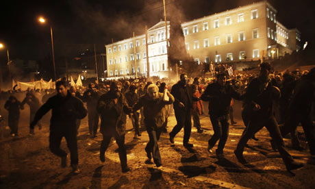 Protesters run away from teargas during clashes near the Greek parliament on February 12, 2012.