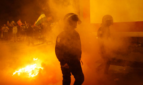 A truck is escorted by riot police officers, at the start of a general strike in Malaga