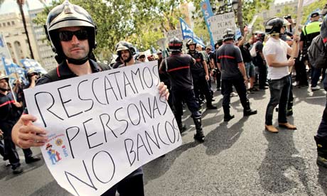 Firefighter's signs reads 'We rescue people, not banks', during a demonstration in Valencia