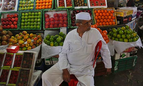 A fruit seller waits for customers at his stall at a wholesale market in Mumbai