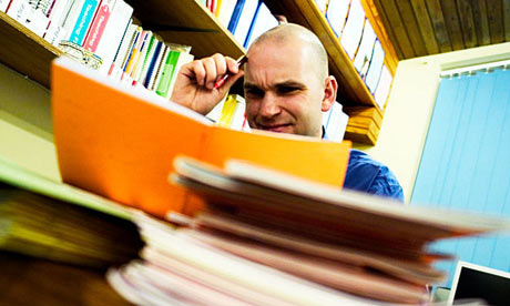Male teacher marking books