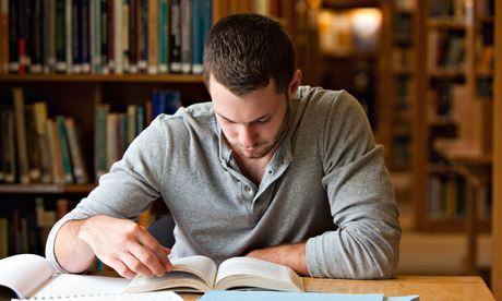 Male student researching with a book