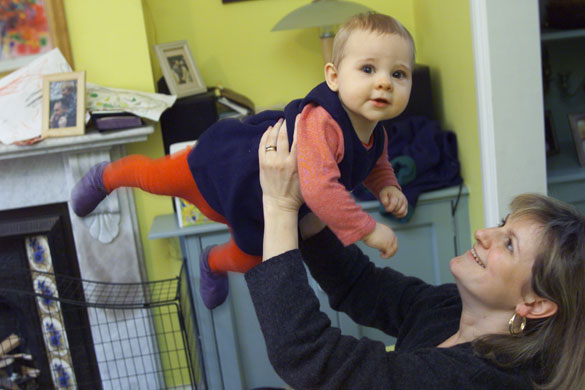 Gallery How to play : A mother holds her toddler up in the air playfully