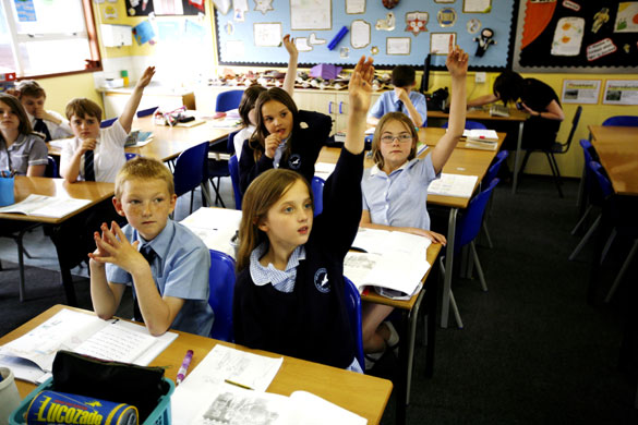 Gallery Apprenticeships: Pupils hold up their hands in class at Heathrow Primary School