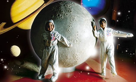Children dressed as astronauts play around a model moon at the National Space Centre, Leicester