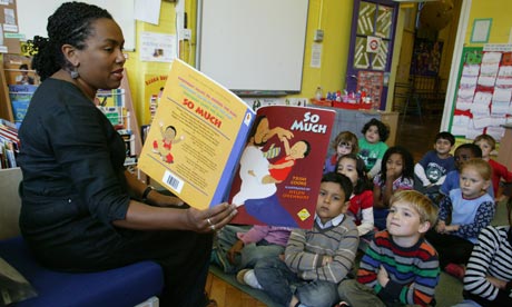 Teacher reads to infant school class