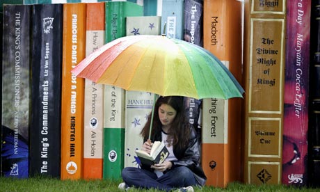 Teenage girl reading with giant books