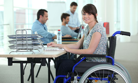 Young woman in wheelchair with laptop computer