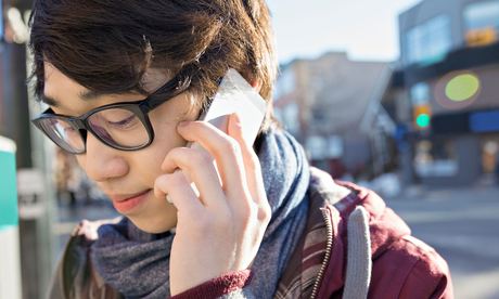 Young man student talking on smart phone outdoors