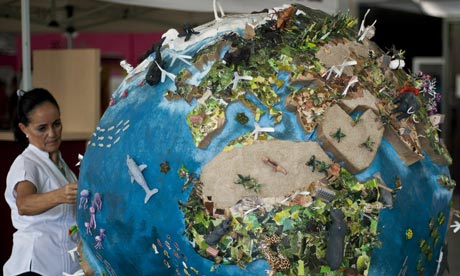 COP16 Cancun : A woman looks at a globe model in the climate village 
