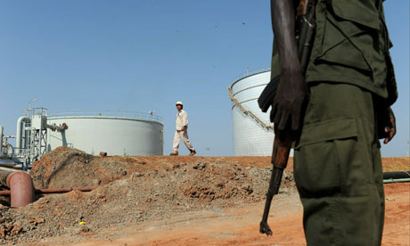 MDG : Southern Sudan referundum : Southern Sudanese soldier standing next to crude oil reservoir